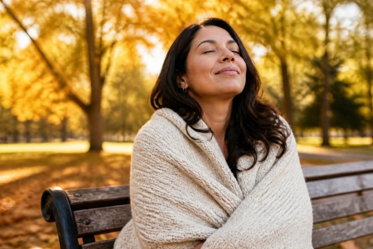 Woman in a cozy sweater breathing calmly on a park bench in autumn - PleaseNotes